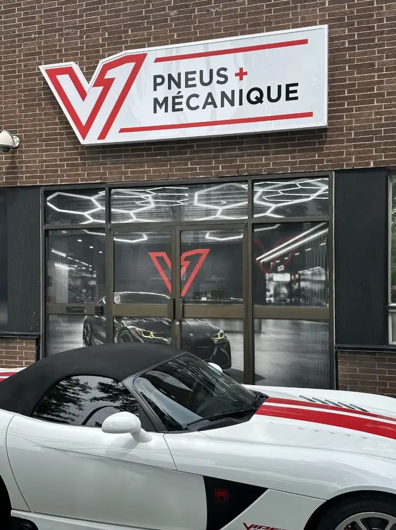 Façade du garage avec l'enseigne rouge V1 Pneus + Mécanique, 9345 rue Pascal-Gagnon, St-Léonard